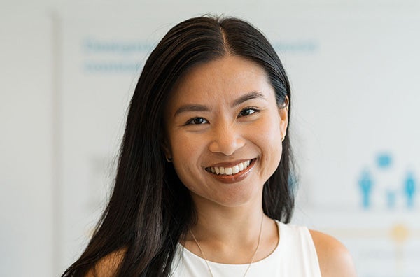 Diana Nguyen with shoulder-length brown hair and wearing a mauve sweater, smiling into the camera