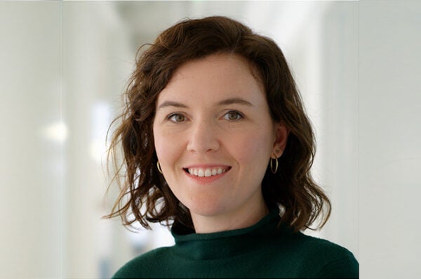 Mary with shoulder length, wavy auburn hair wearing a dark green turtleneck